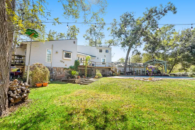 a view of swimming pool with outdoor seating and trees in the background
