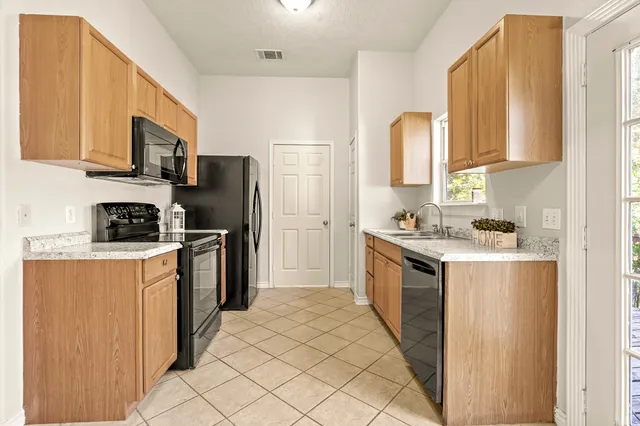 a kitchen with stainless steel appliances granite countertop a refrigerator stove top oven a sink and dishwasher
