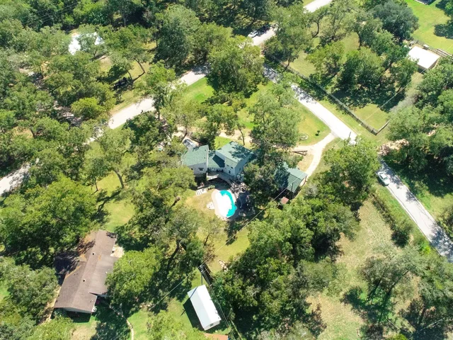 an aerial view of a residential houses with yard