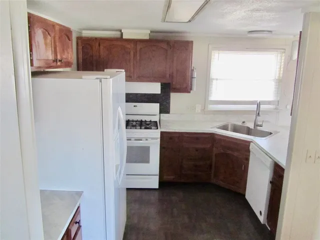 a kitchen with a refrigerator sink and cabinets