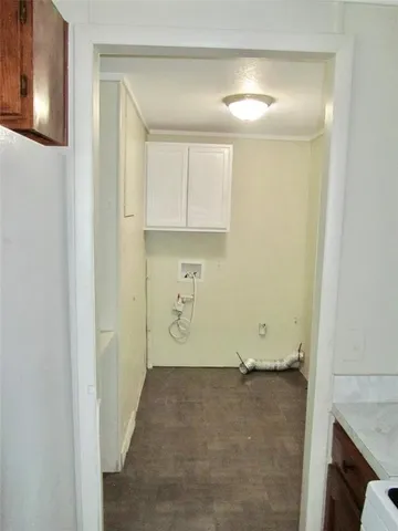 a view of a room with wooden floor and cabinets