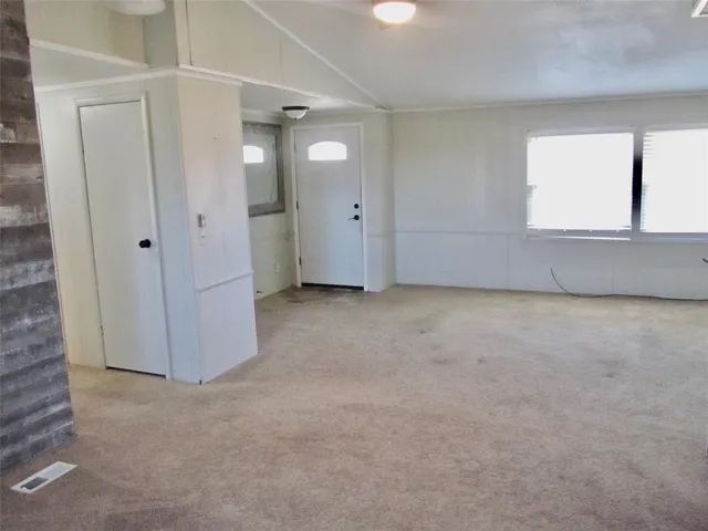 an empty room with windows and closet