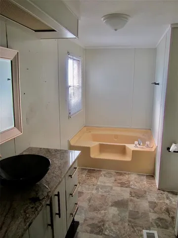 a bathroom with a granite countertop sink a toilet and bathtub