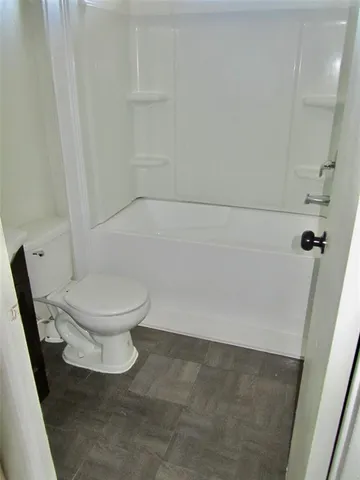 a white toilet sitting next to a shower