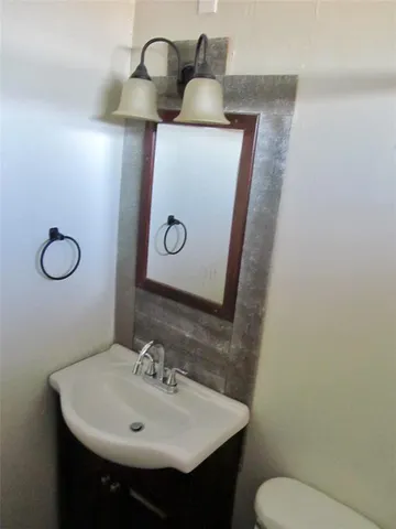 a bathroom with a sink toilet and mirror