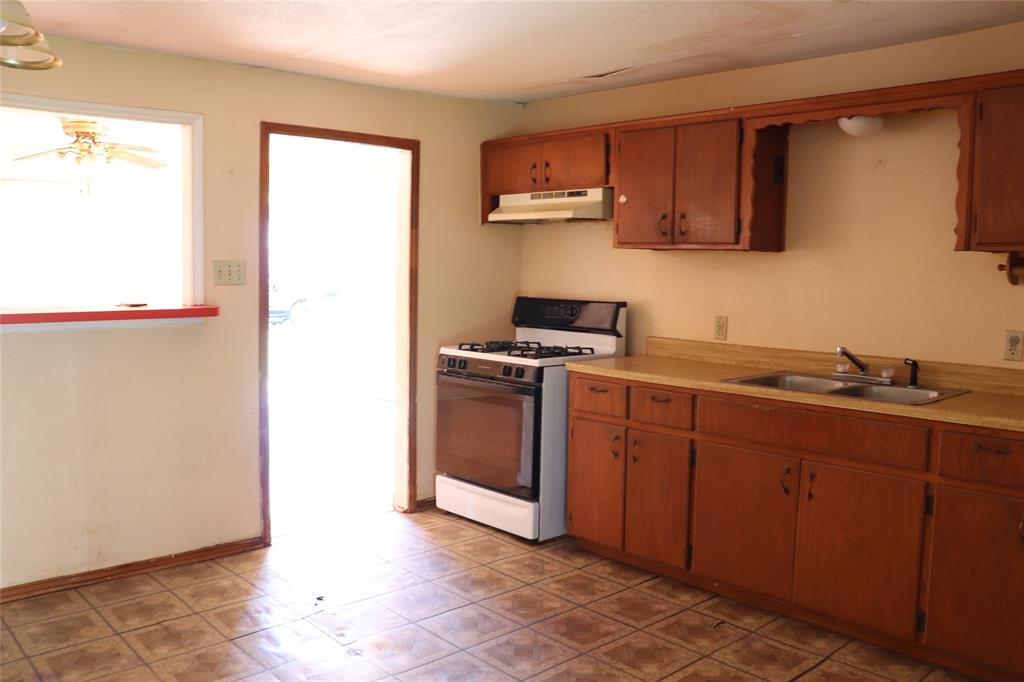 916 Poindexter Avenue Cleburne, TX 76033 - Photo 4 of 10 a kitchen with stainless steel appliances granite countertop a sink and a stove top oven