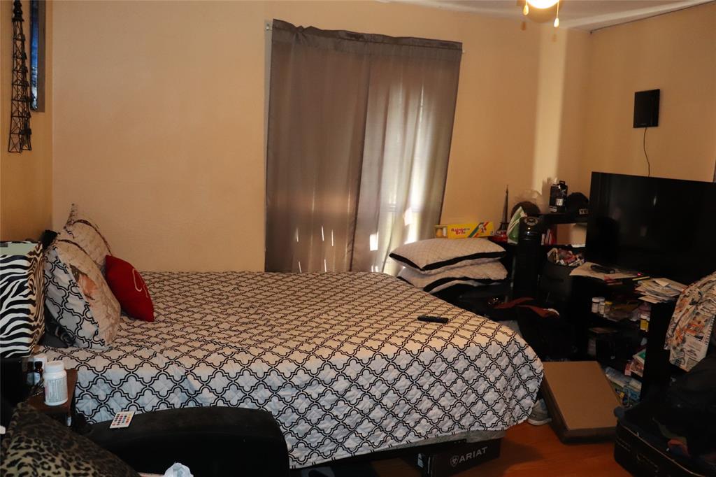 916 Poindexter Avenue Cleburne, TX 76033 - Photo 6 of 10 a bedroom with a bed and dresser with mirror