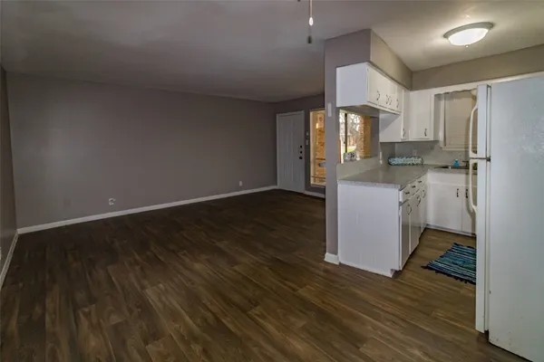 a kitchen with wooden floor and refrigerator