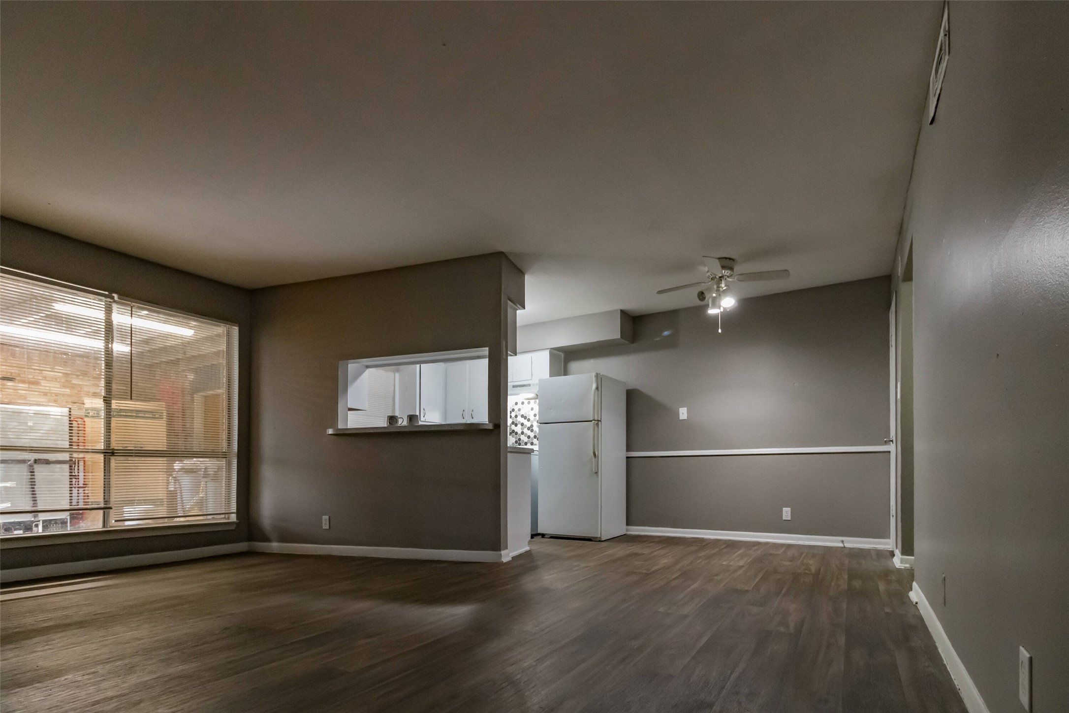 1305 Memorial Drive, Unit 6 Baytown, TX 77520 - Photo 9 of 19 an empty room with wooden floor kitchen view and windows