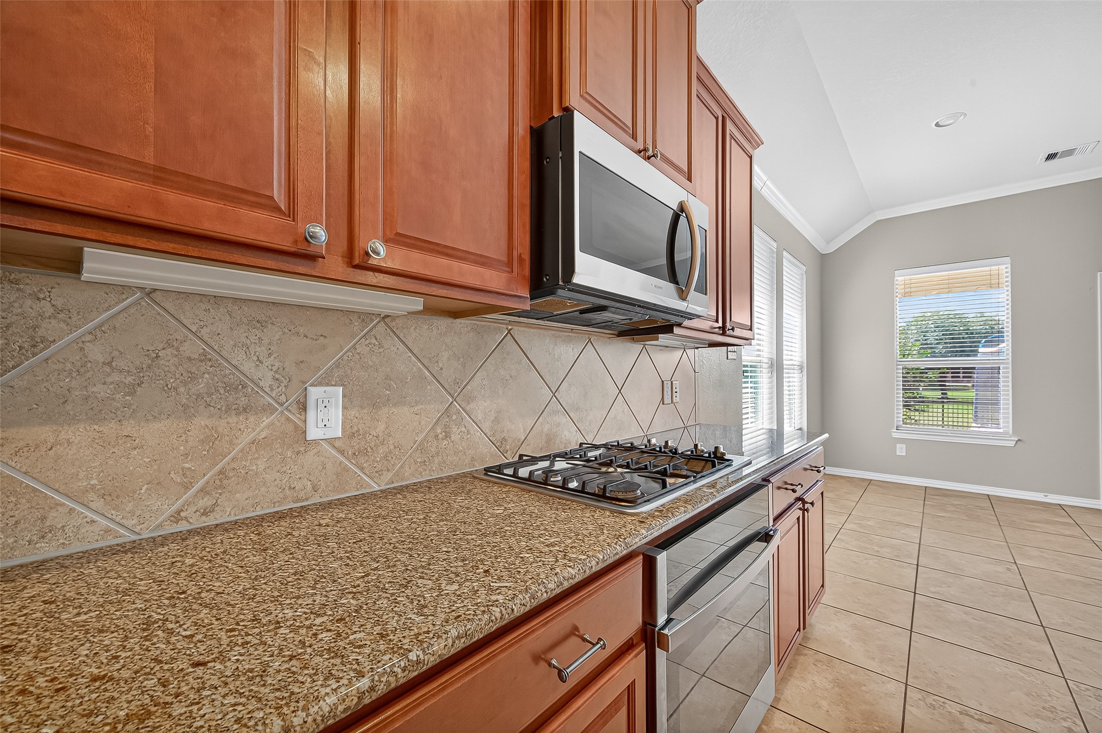 2019 Preston Park Rosenberg, TX 77471 - Photo 13 of 31 a kitchen with granite countertop a sink stove and microwave