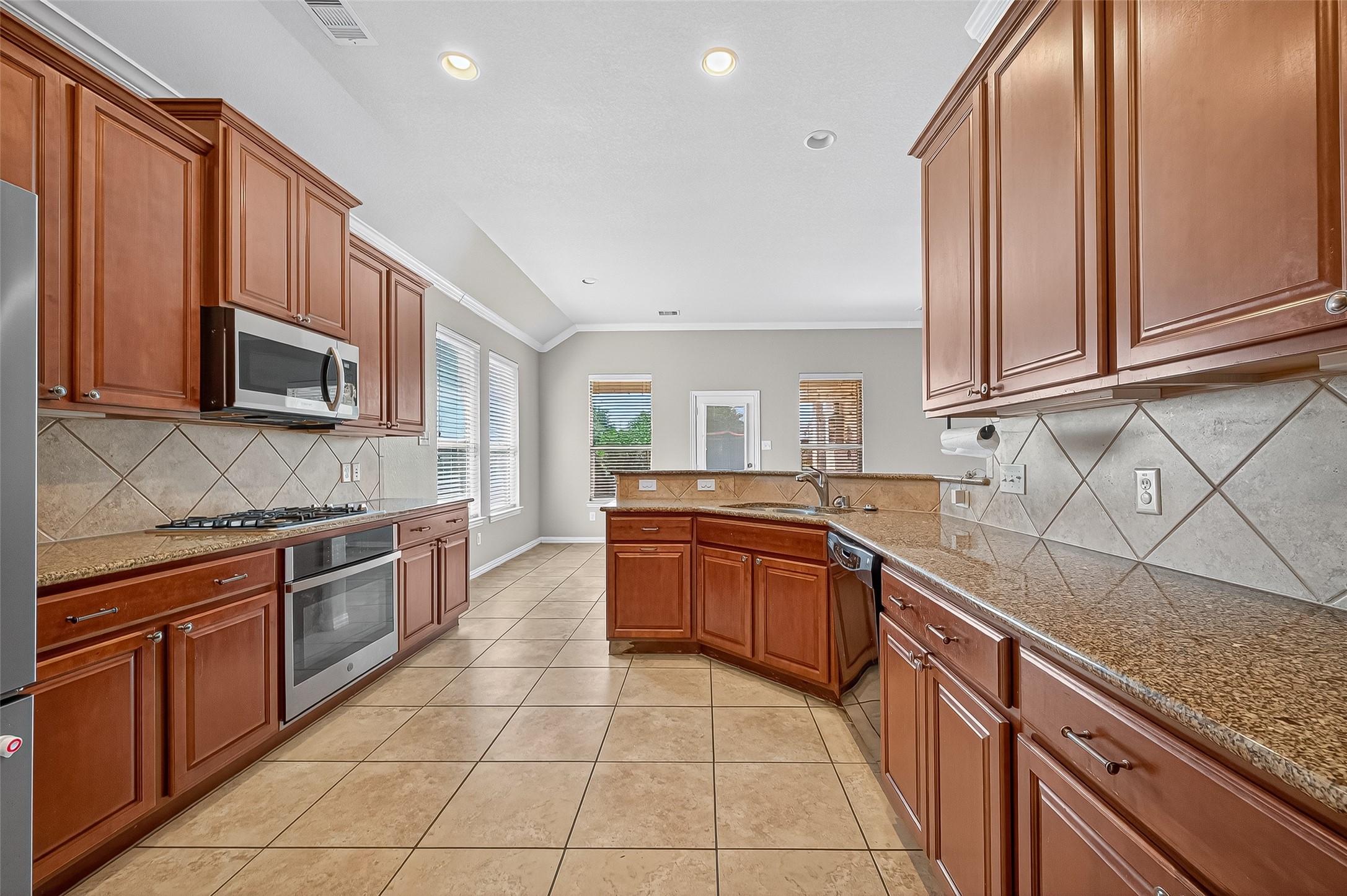 2019 Preston Park Rosenberg, TX 77471 - Photo 10 of 31 a kitchen with stainless steel appliances granite countertop wooden cabinets a granite counter top and a sink