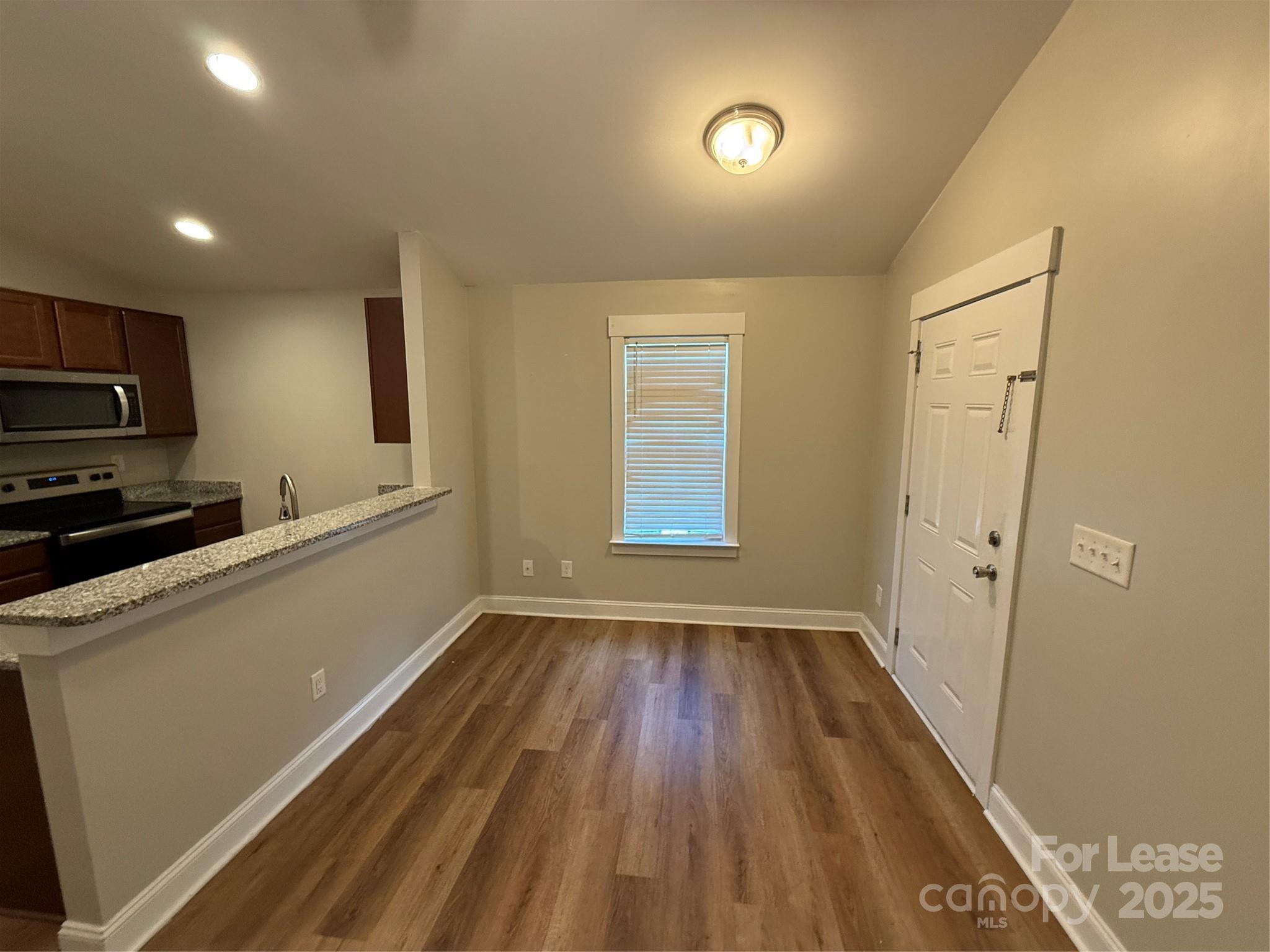 664 Reeves Court Charlotte, NC 28208 - Photo 3 of 9 a view of an empty room with a window and wooden floor