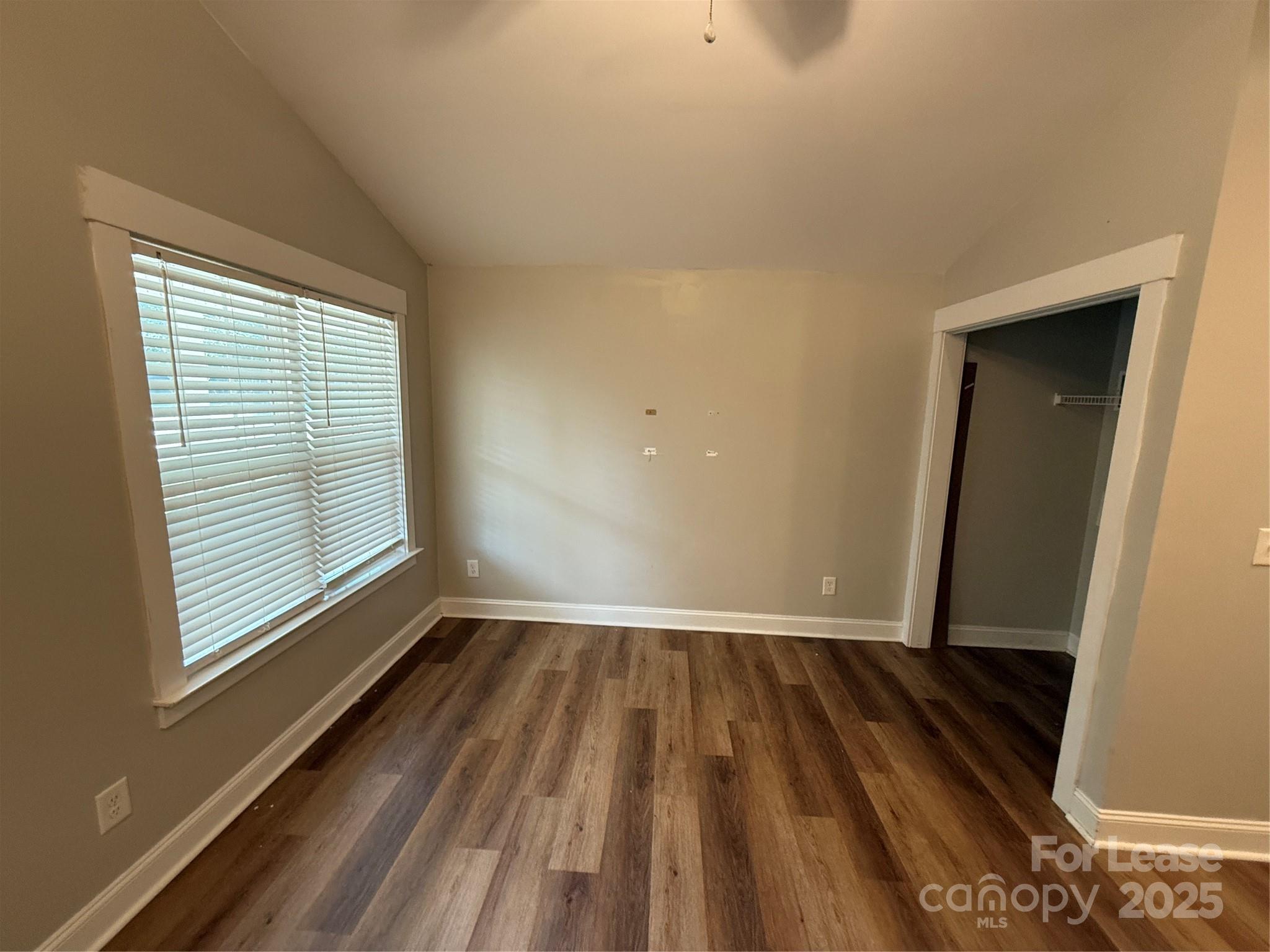 664 Reeves Court Charlotte, NC 28208 - Photo 5 of 9 a view of an empty room with wooden floor and a window