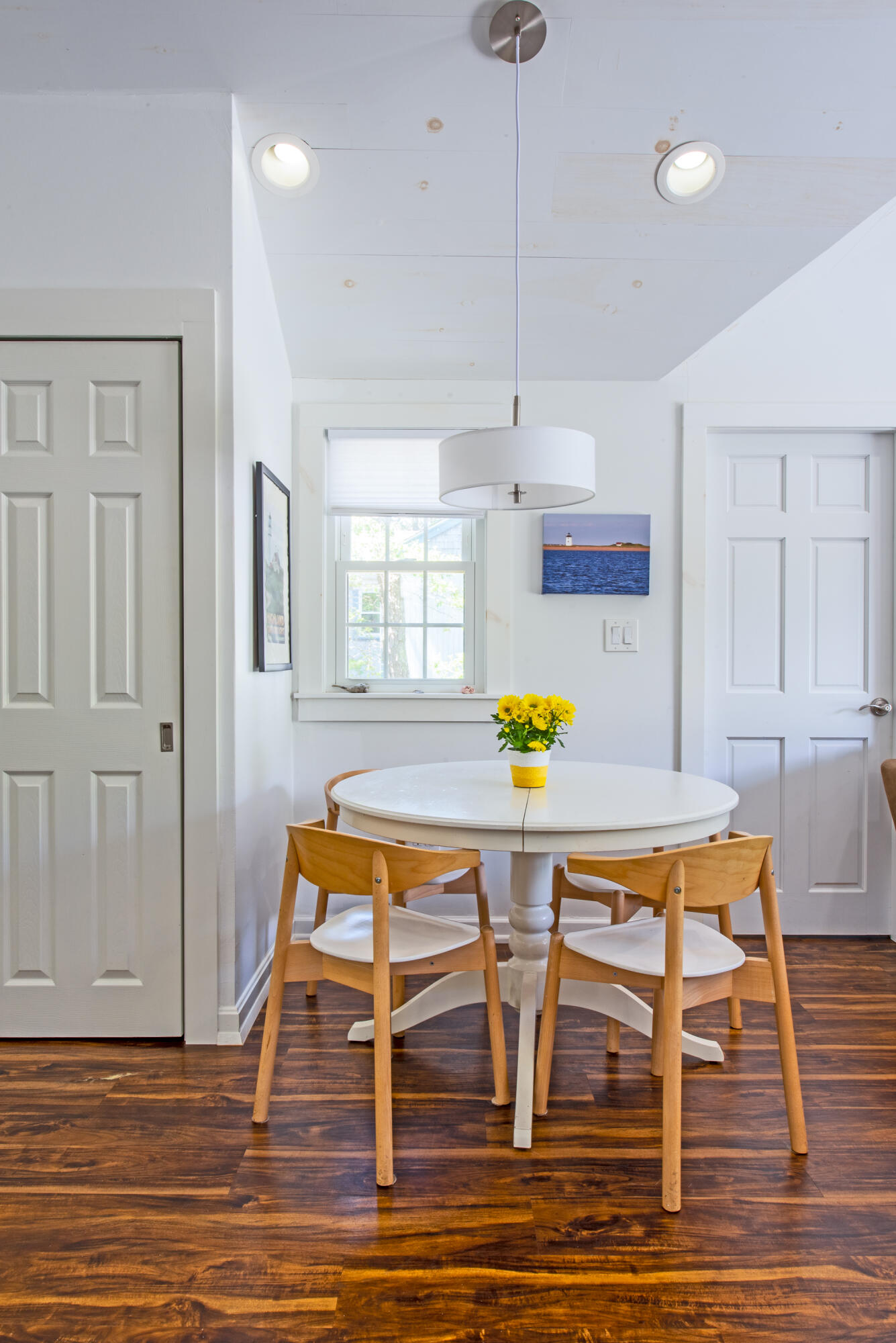 7 Great Hollow Road, Unit 38 Truro, MA 02666 - Photo 13 of 28 a dining room with wooden floor a chandelier a wooden table and chairs