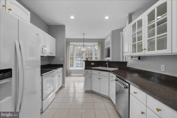 a kitchen with granite countertop a sink a stove and cabinets