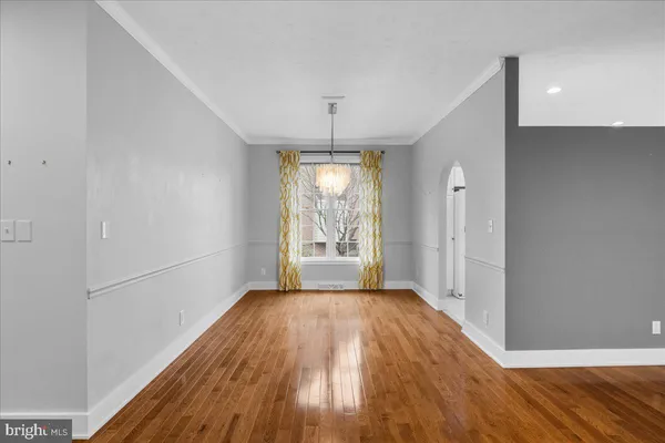a view of a hallway with wooden floor and a bathroom