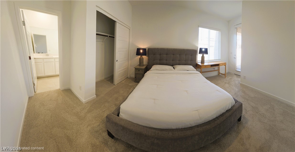 509 Arthur Pointe Street Henderson, NV 89011 - Photo 3 of 12 A well-lit bedroom features plush carpet and convenient access to a private bathroom and closet space.