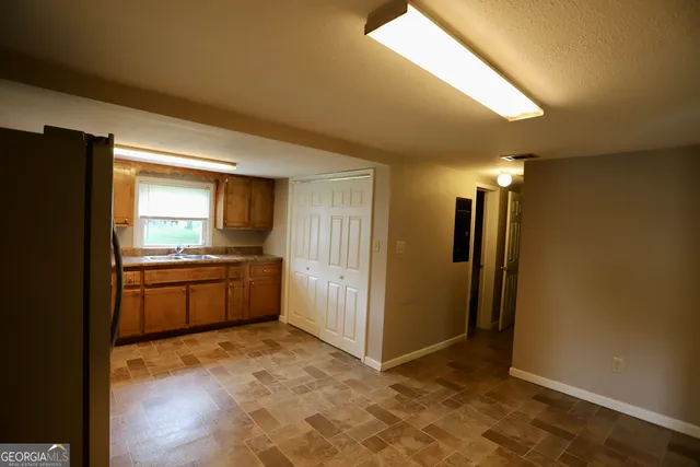 a large kitchen with a sink and refrigerator