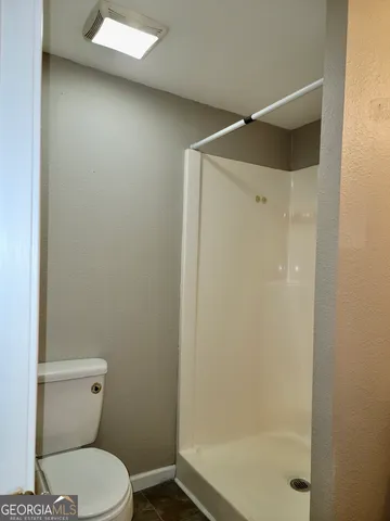 a bathroom with a toilet and a shower