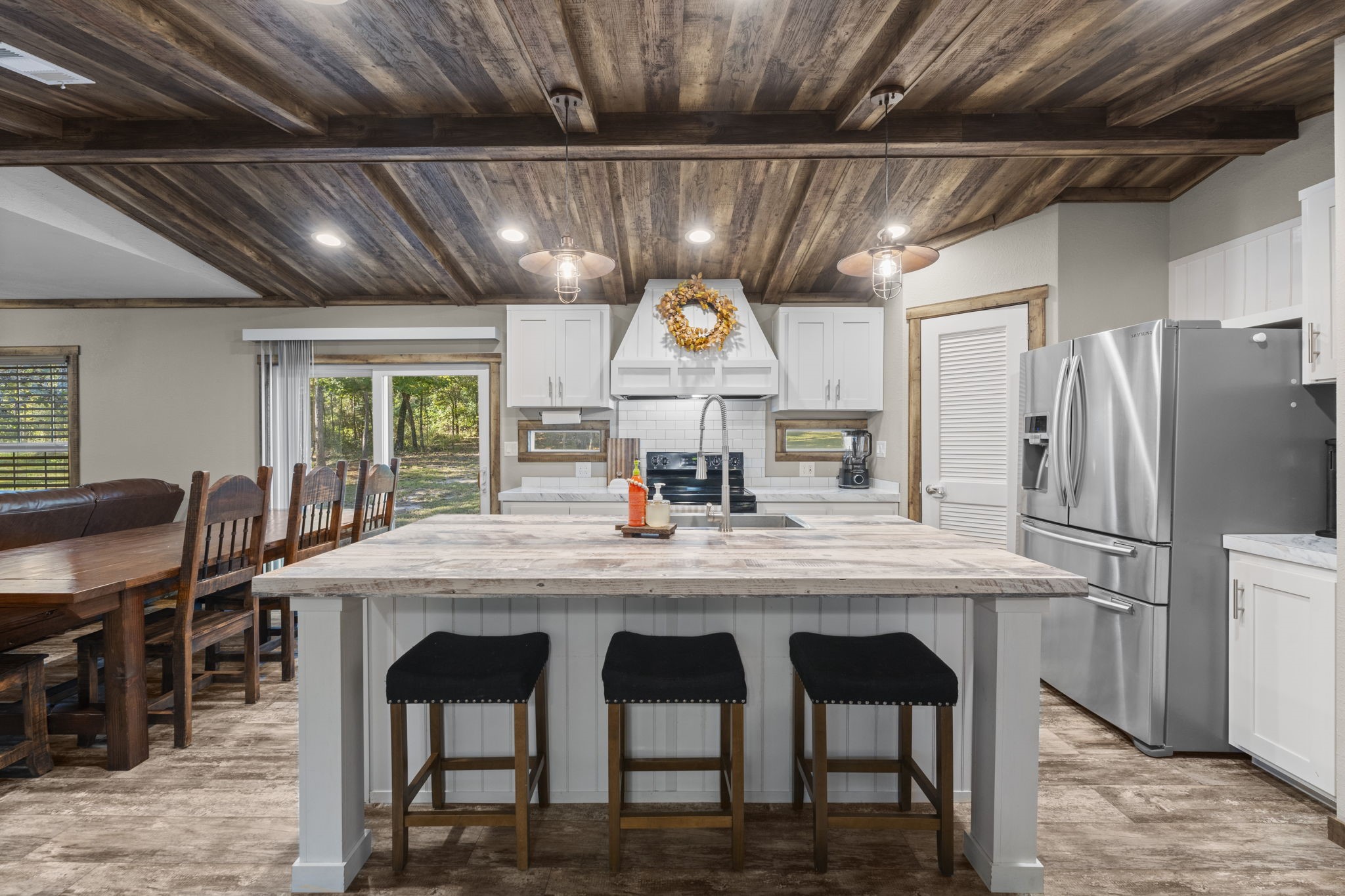 577 Winding River Road South Oakhurst, TX 77359 - Photo 7 of 31 a kitchen with stainless steel appliances granite countertop a table chairs and a refrigerator