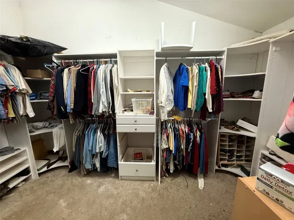 a view of walk in closet with clothes and shoes