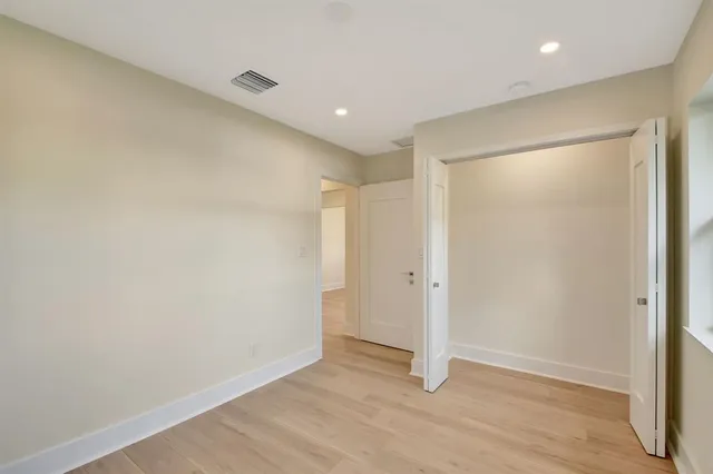 an empty room with wooden floor and a window