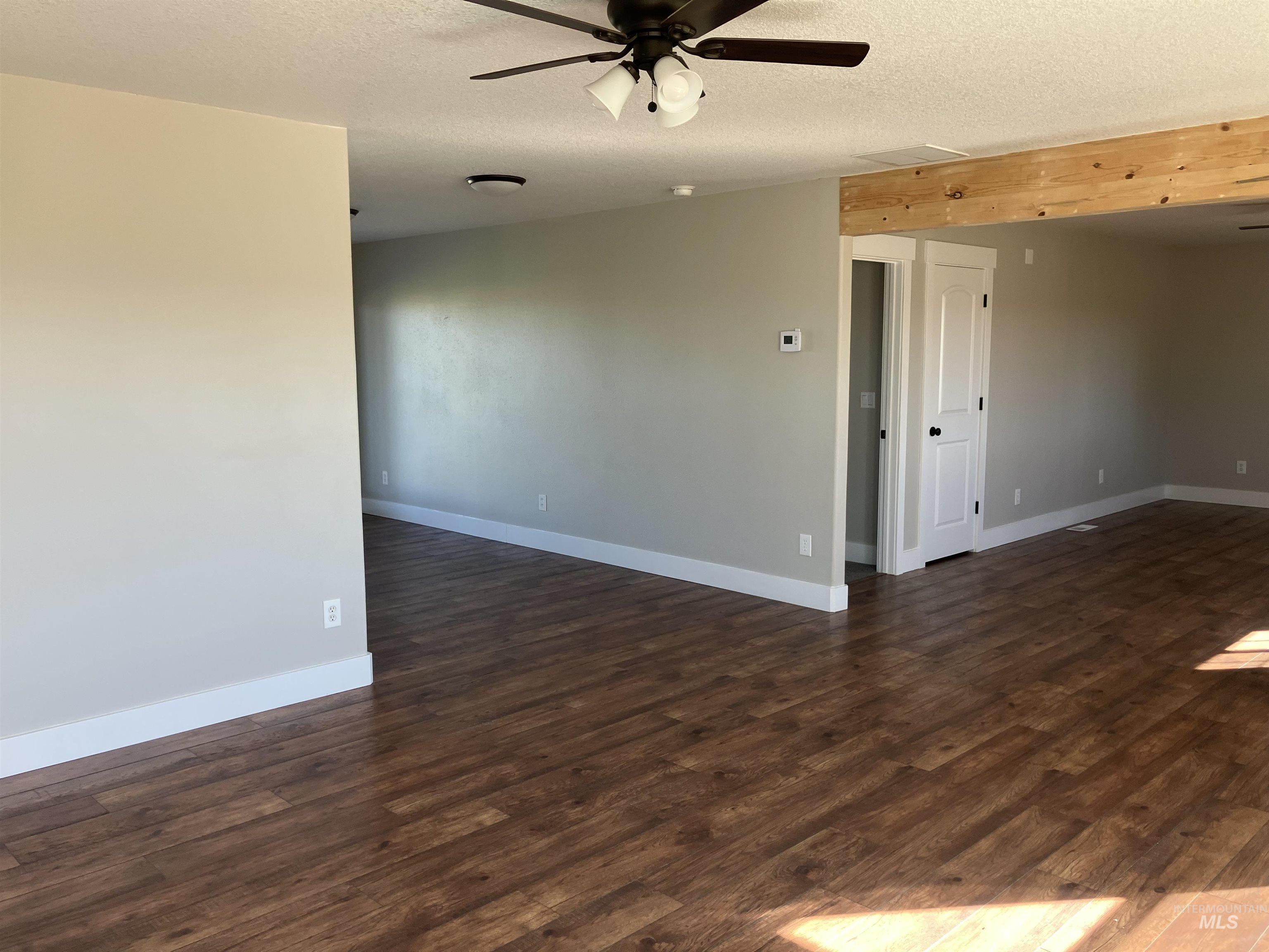 17530 Beet Road Caldwell, ID 83607 - Photo 13 of 50 Unfurnished room with dark wood finished floors, a textured ceiling, and a ceiling fan