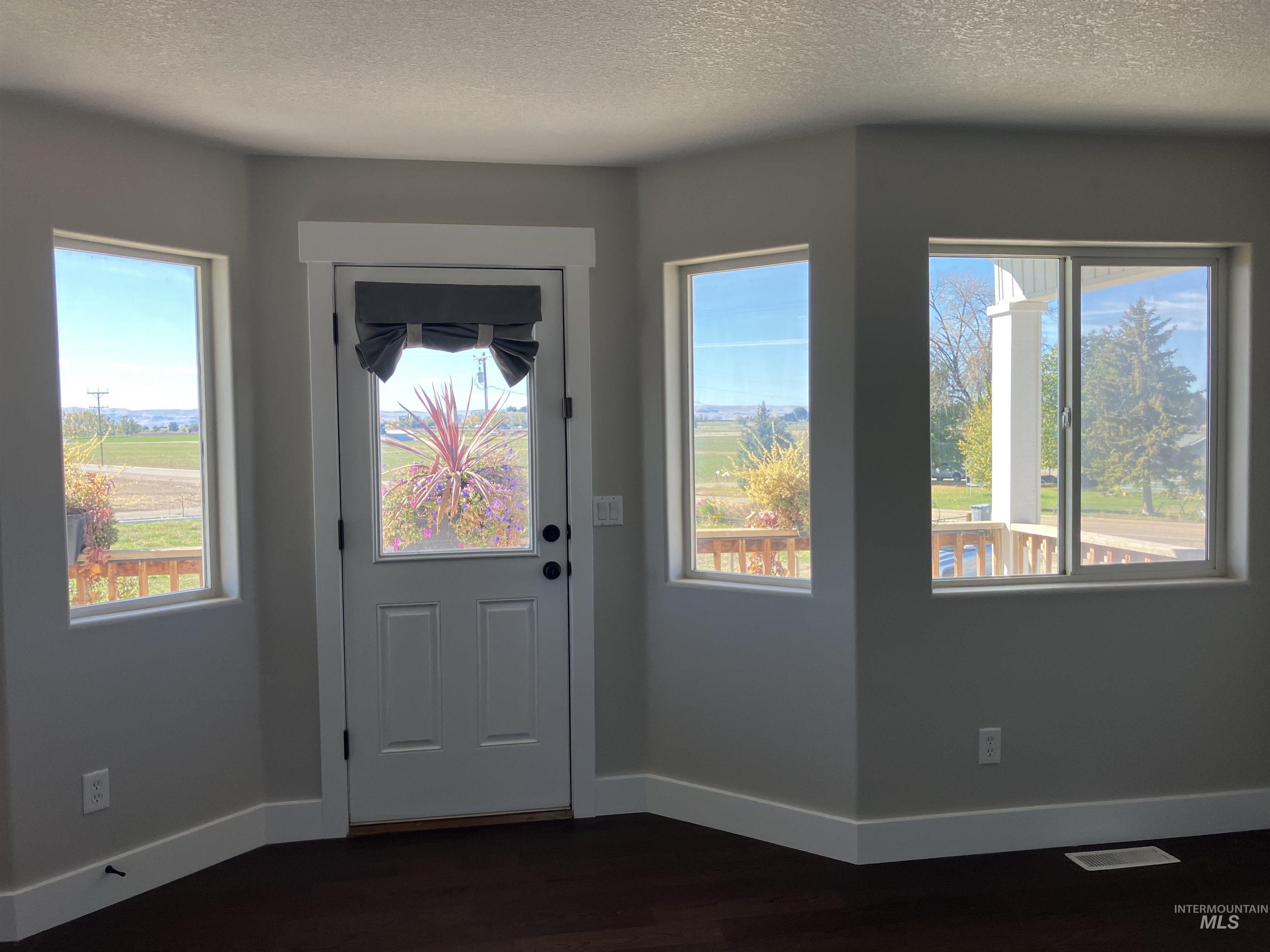 17530 Beet Road Caldwell, ID 83607 - Photo 32 of 50 Upstairs Bedroom featuring a textured ceiling, healthy amount of natural light, and wood finished floors and access to a balcony deck