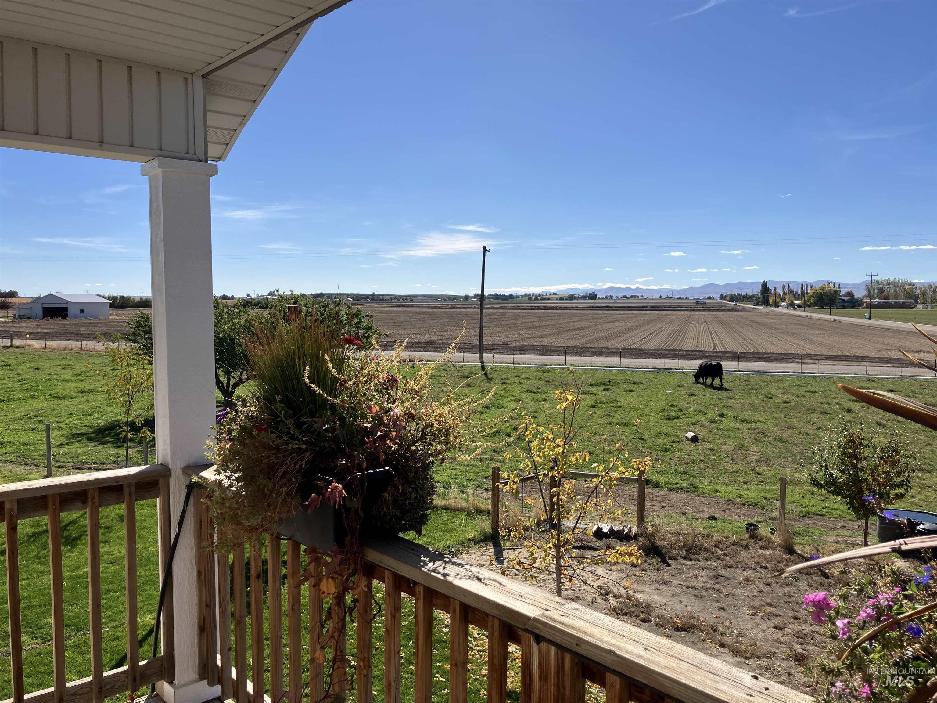 17530 Beet Road Caldwell, ID 83607 - Photo 34 of 50 View of green lawn with a rural view, a balcony, and agricultural area from upper bedroom or could be a bonus room.