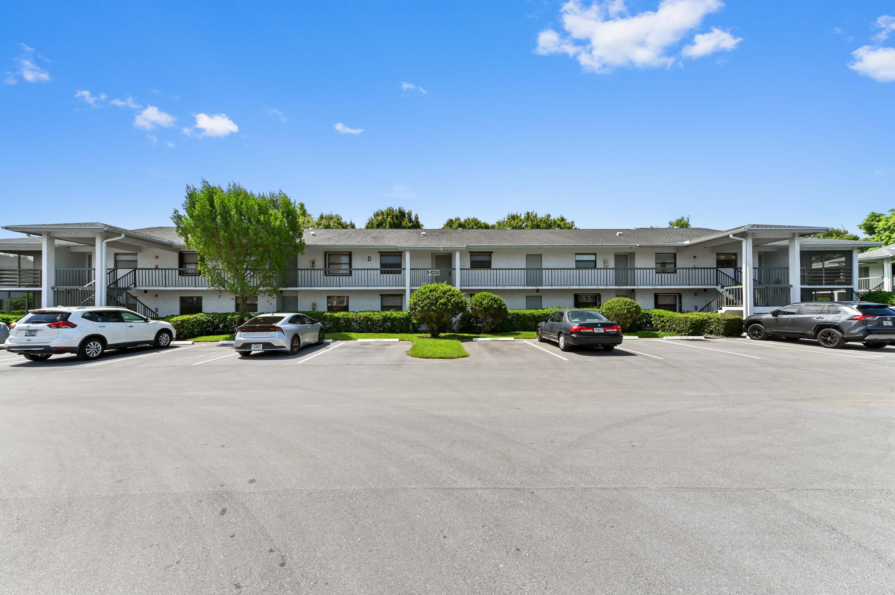 1230 Southeast Parkview Place, Unit D2 Stuart, FL 34994 - Photo 1 of 34 a city street lined with parked cars and buildings