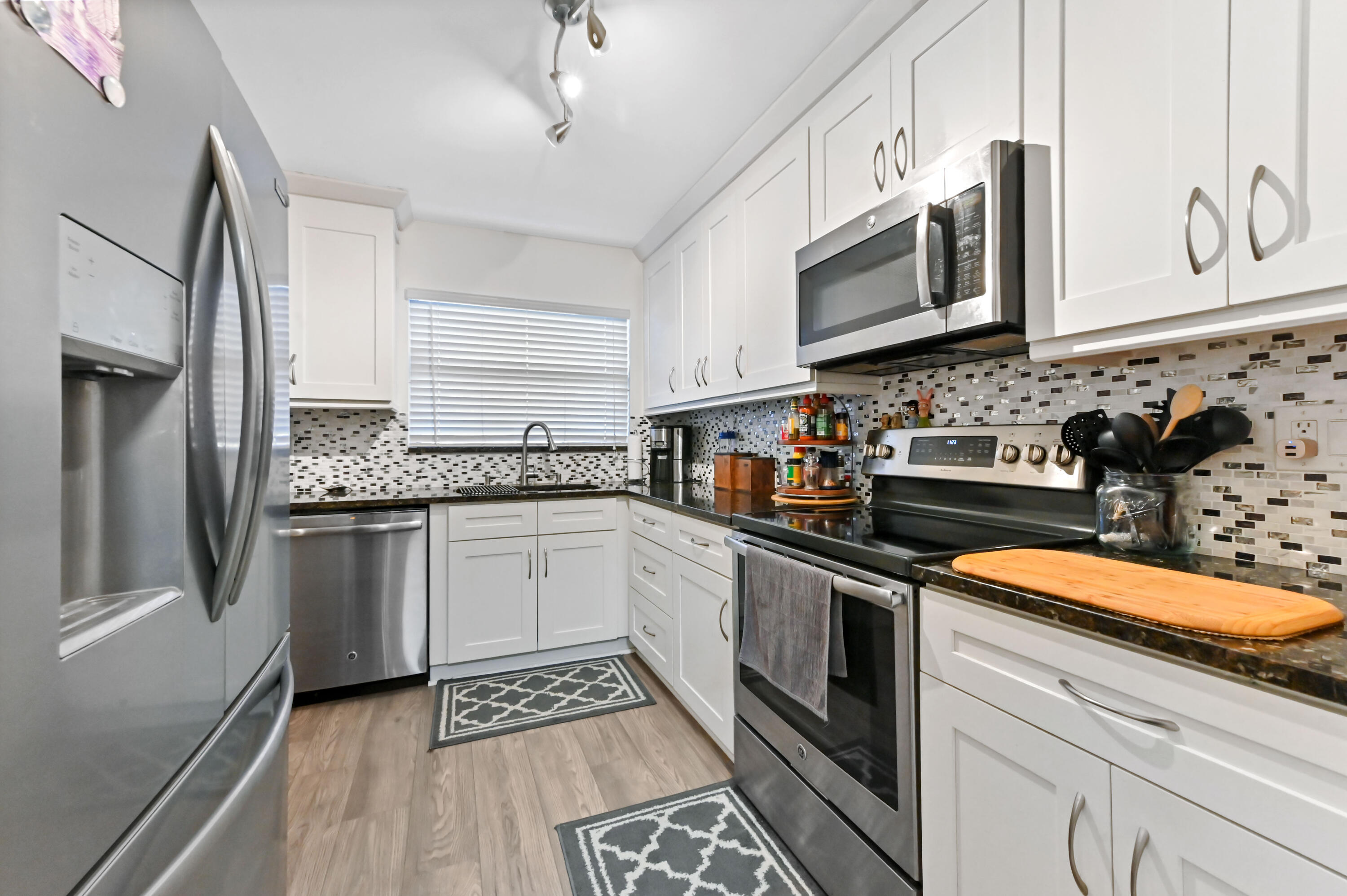 1230 Southeast Parkview Place, Unit D2 Stuart, FL 34994 - Photo 12 of 34 a kitchen with stainless steel appliances granite countertop a sink stove and microwave