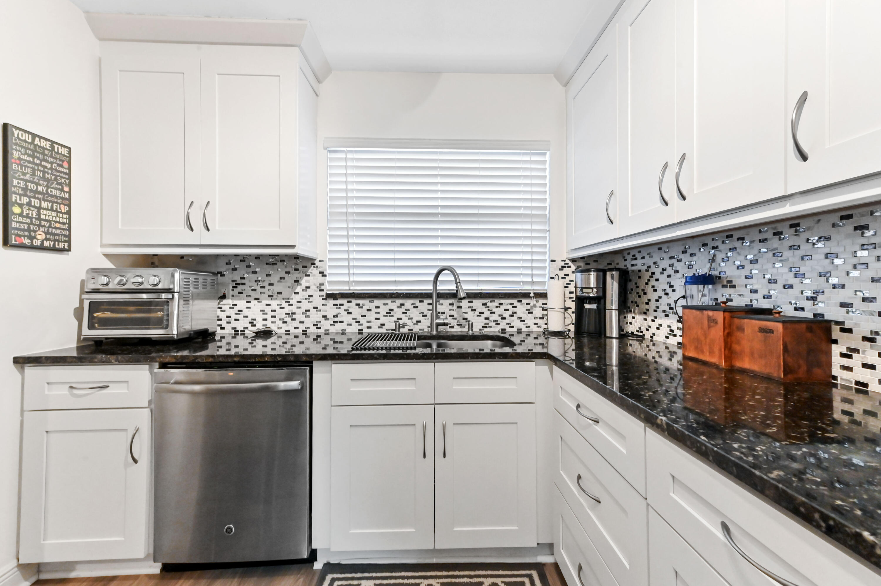 1230 Southeast Parkview Place, Unit D2 Stuart, FL 34994 - Photo 13 of 34 a kitchen with granite countertop white cabinets and white appliances
