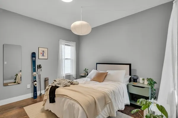 a bedroom with a bed and wooden floor