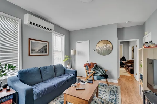 a living room with furniture a flat screen tv and a large window