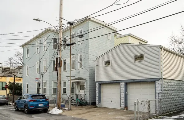 a car parked in front of a white house