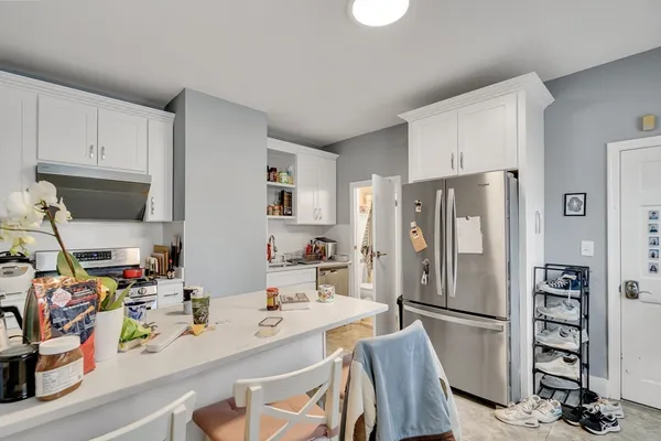 a kitchen with stainless steel appliances a refrigerator a sink a stove and a refrigerator