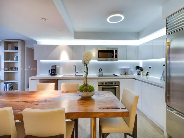 a kitchen with kitchen island a stove a table and chairs in it