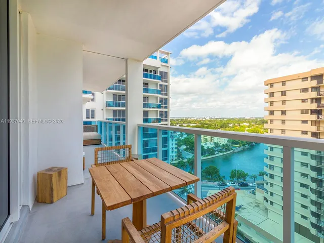 a view of a balcony with table and chairs and wooden fence