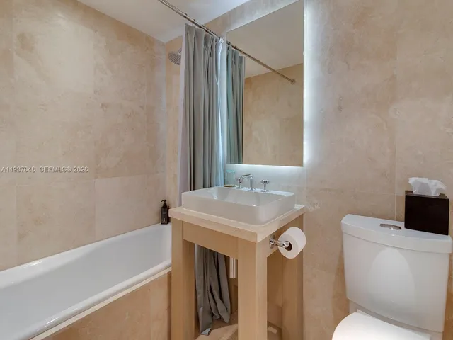 a bathroom with a sink toilet vanity and tub