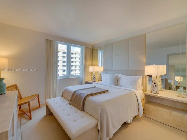 a bedroom with a bed and a large mirror