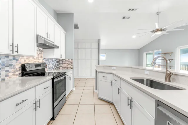 a kitchen with stainless steel appliances a sink a stove a refrigerator and cabinets