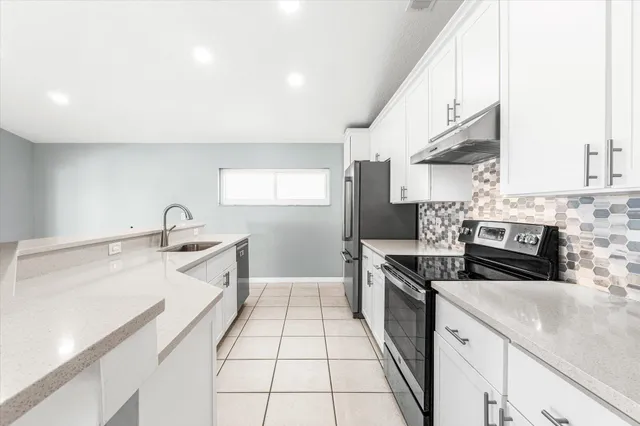 a kitchen with stainless steel appliances a refrigerator sink and microwave