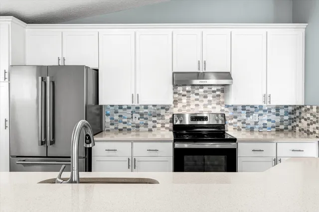 a kitchen with stainless steel appliances granite countertop a sink and a stove