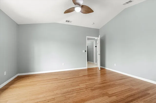 a view of an empty room with wooden floor