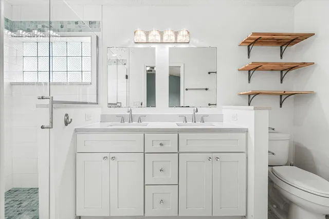 a bathroom with a granite countertop sink a toilet and a mirror