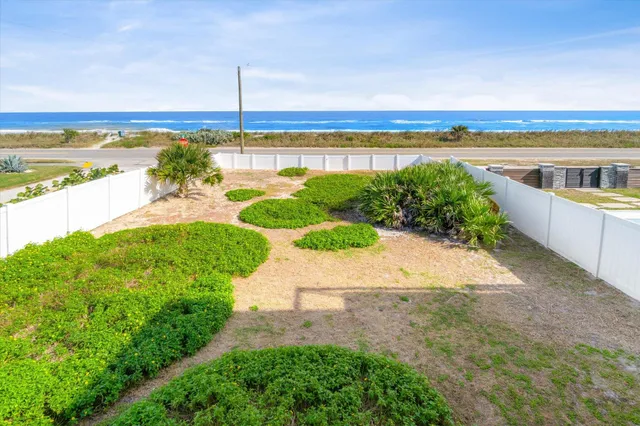 a view of an house with backyard and road