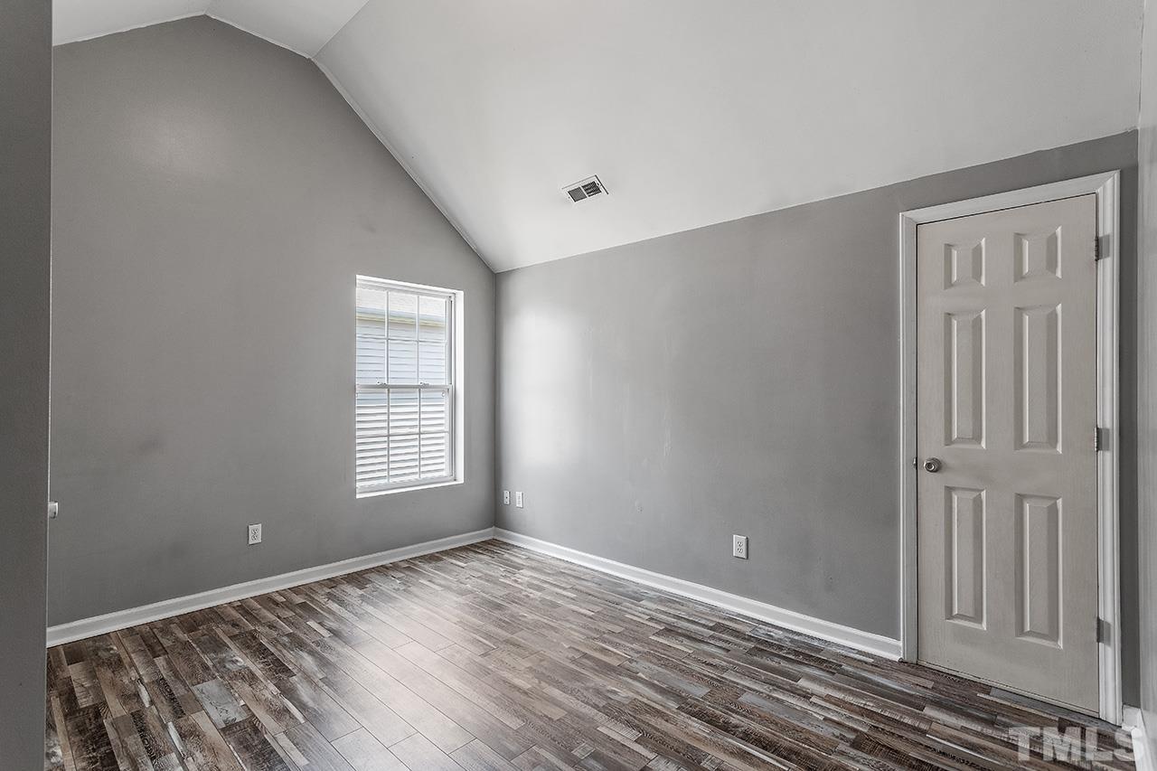 4236 Dalcross Road Raleigh, NC 27610 - Photo 13 of 14 a view of an empty room with wooden floor and a window