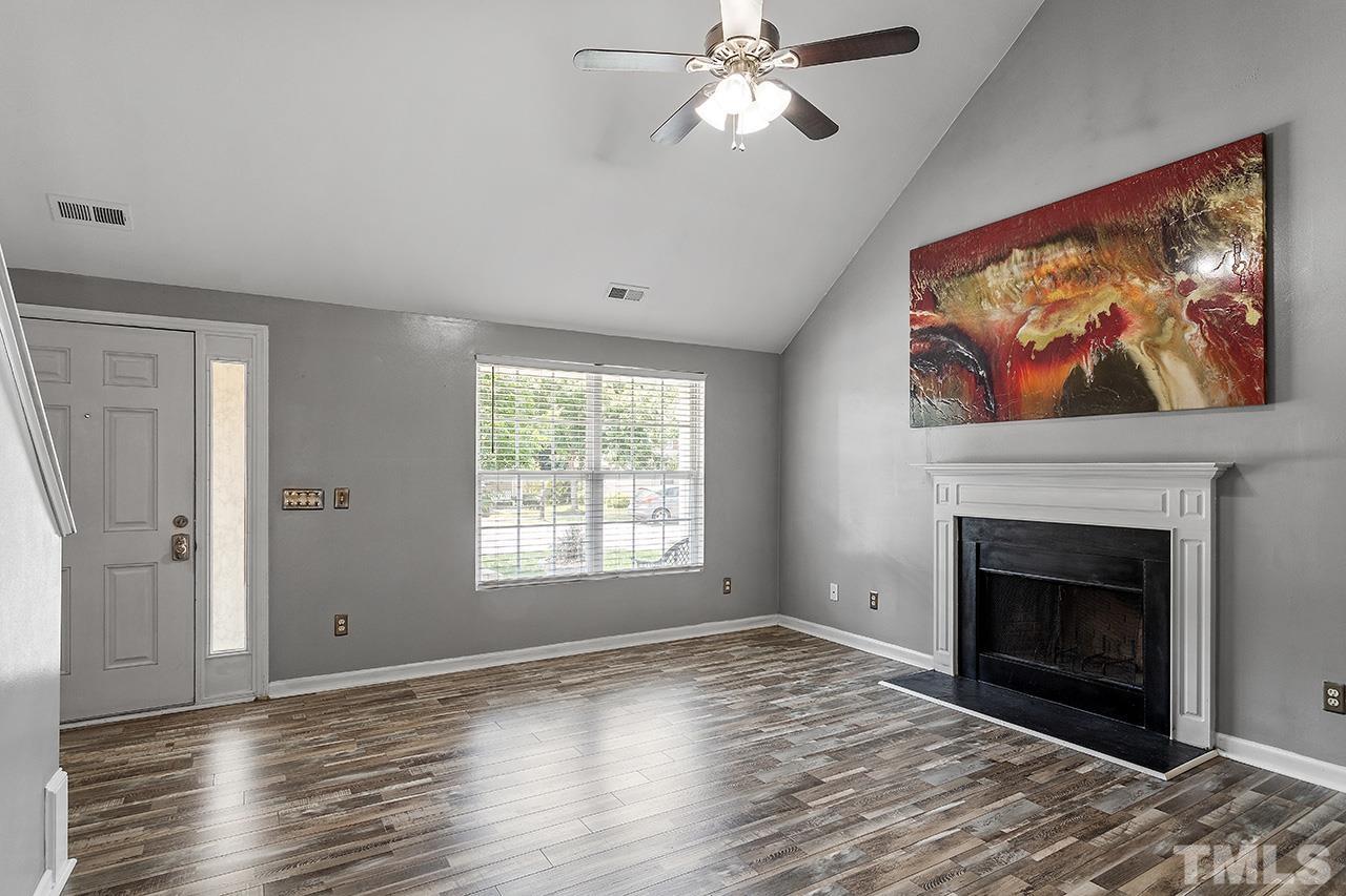 4236 Dalcross Road Raleigh, NC 27610 - Photo 5 of 14 a view of empty room with wooden floor and fireplace