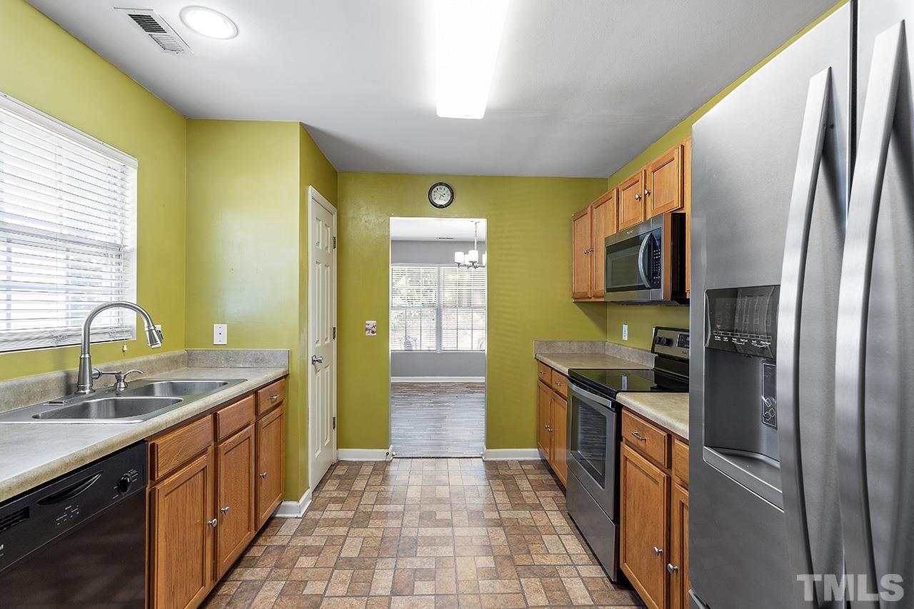 4236 Dalcross Road Raleigh, NC 27610 - Photo 7 of 14 a kitchen with stainless steel appliances granite countertop a sink and a refrigerator