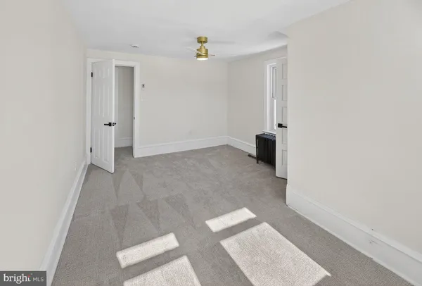 an empty room with an entryway and chandelier